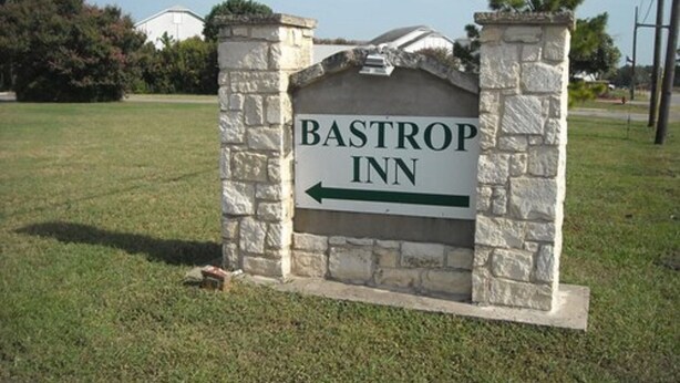 A sign for BASTROP INN with an arrow pointing left. - Bastrop Inn (Bastrop)