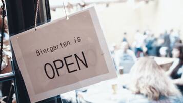 Um letreiro com a mensagem 'Biergarten está ABERTO' em um espaço público.