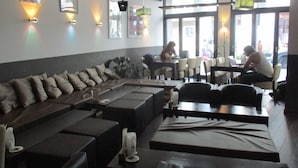 Un restaurante moderno con una amplia zona de mesas compartidas, mesas individuales e iluminación colgante.