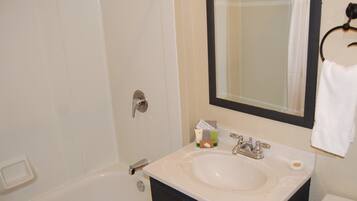 A bathroom with a white sink, a mirror, a towel rack, and a shower curtain.