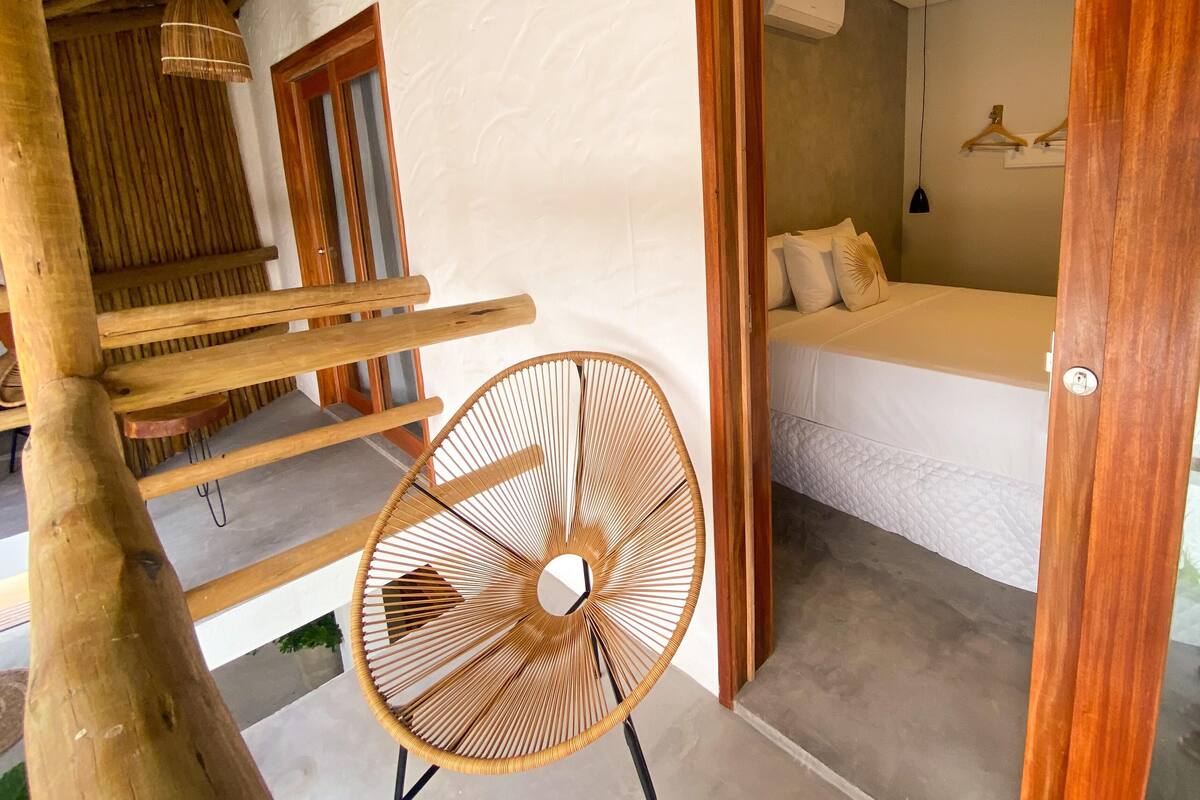 Ein Zimmer mit einem Bett, einem Ventilator und einer Holztreppe.