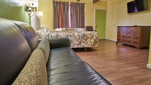 A bedroom with a bed, a sofa, a dresser, and a television. - Budget Inn Vallejo/Napa Valley (Vallejo)
