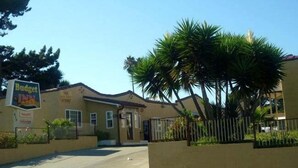 A building with a sign for Budget Inn, featuring a simple facade with a flat roof and a small entrance. - Budget Inn Vallejo/Napa Valley (Vallejo)