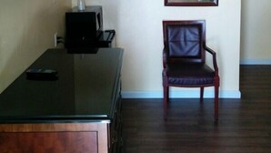 A room with a wooden cabinet, a television, a mirror, and a chair. - Budget Inn Vallejo/Napa Valley (Vallejo)