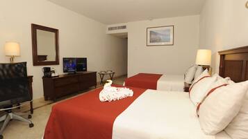 A hotel room with two beds, a desk, a chair, a television, and a framed picture on the wall.