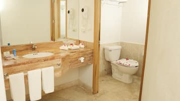 A bathroom with a marble sink, a toilet, and a mirror.