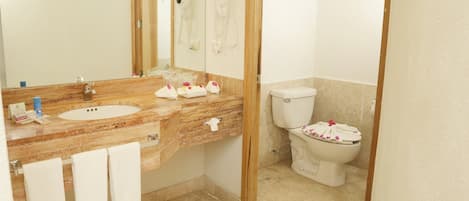 Un baño con lavamanos de mármol, inodoro y espejo.
