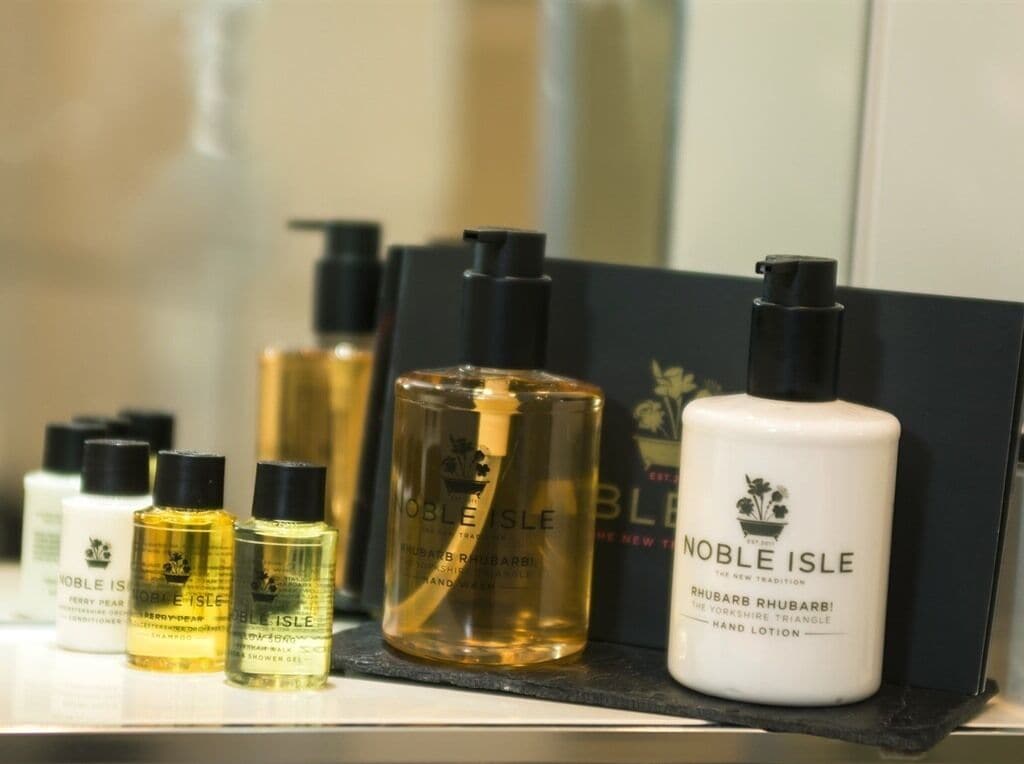 A display of Noble Isle hand care products including hand lotion, shower gel, and shampoo.
