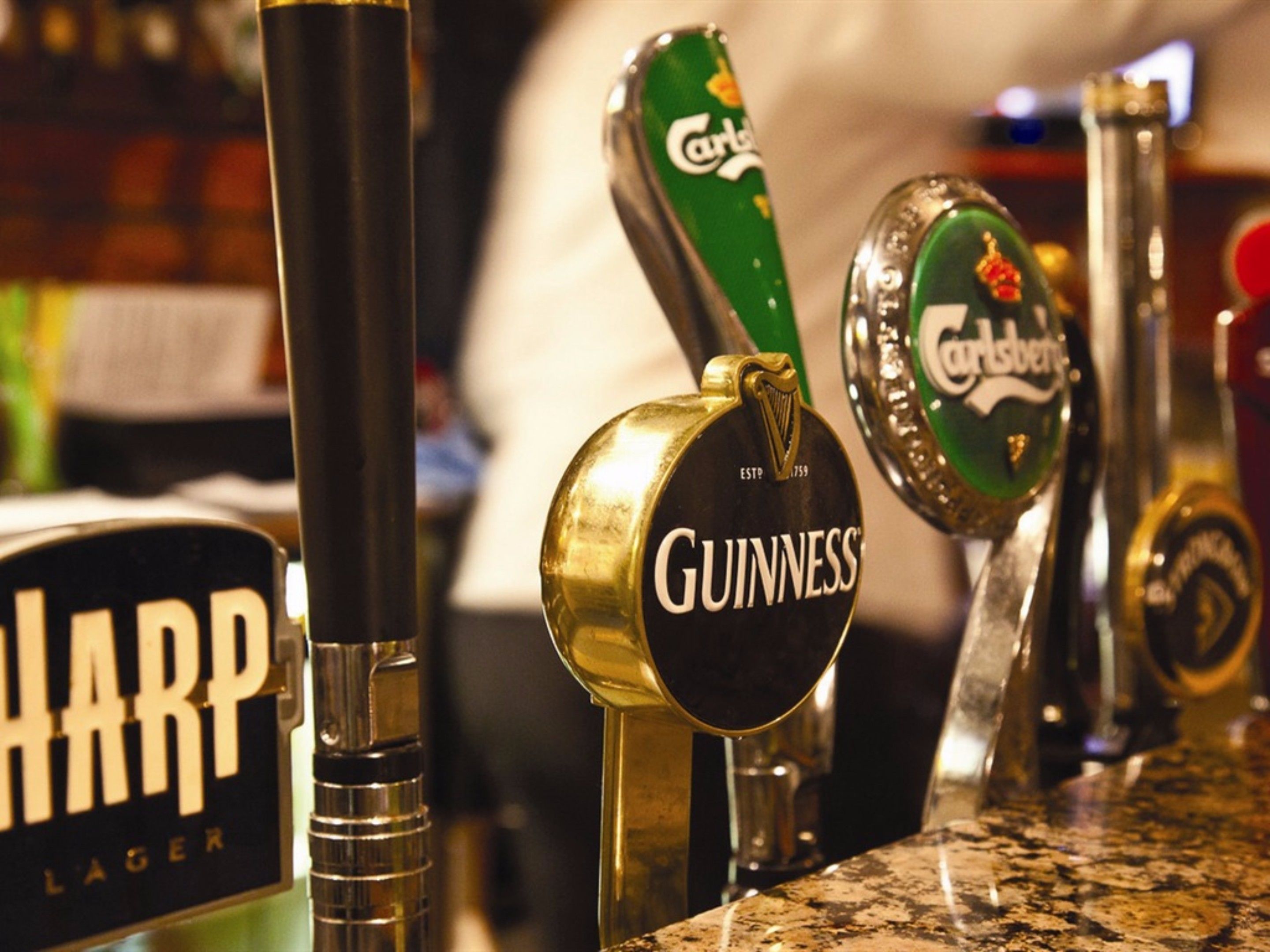 A bar with multiple beer taps, including brands like Guinness and Carlsberg.