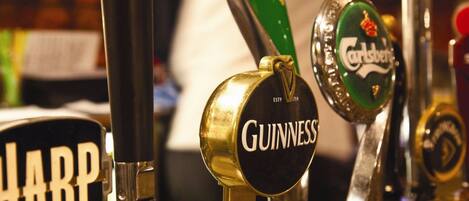 A bar with multiple beer taps, including brands like Guinness and Carlsberg.