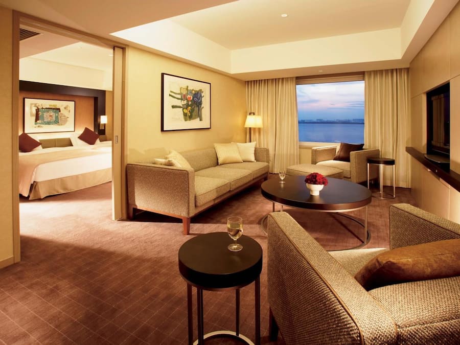 Une chambre d’hôtel avec un lit, un canapé, une table basse et un téléviseur.