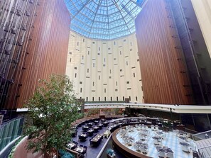 A spacious atrium with a high ceiling and a glass dome, surrounded by multiple dining areas with tables and chairs. - Maihama View Hotel by HULIC (Urayasu)