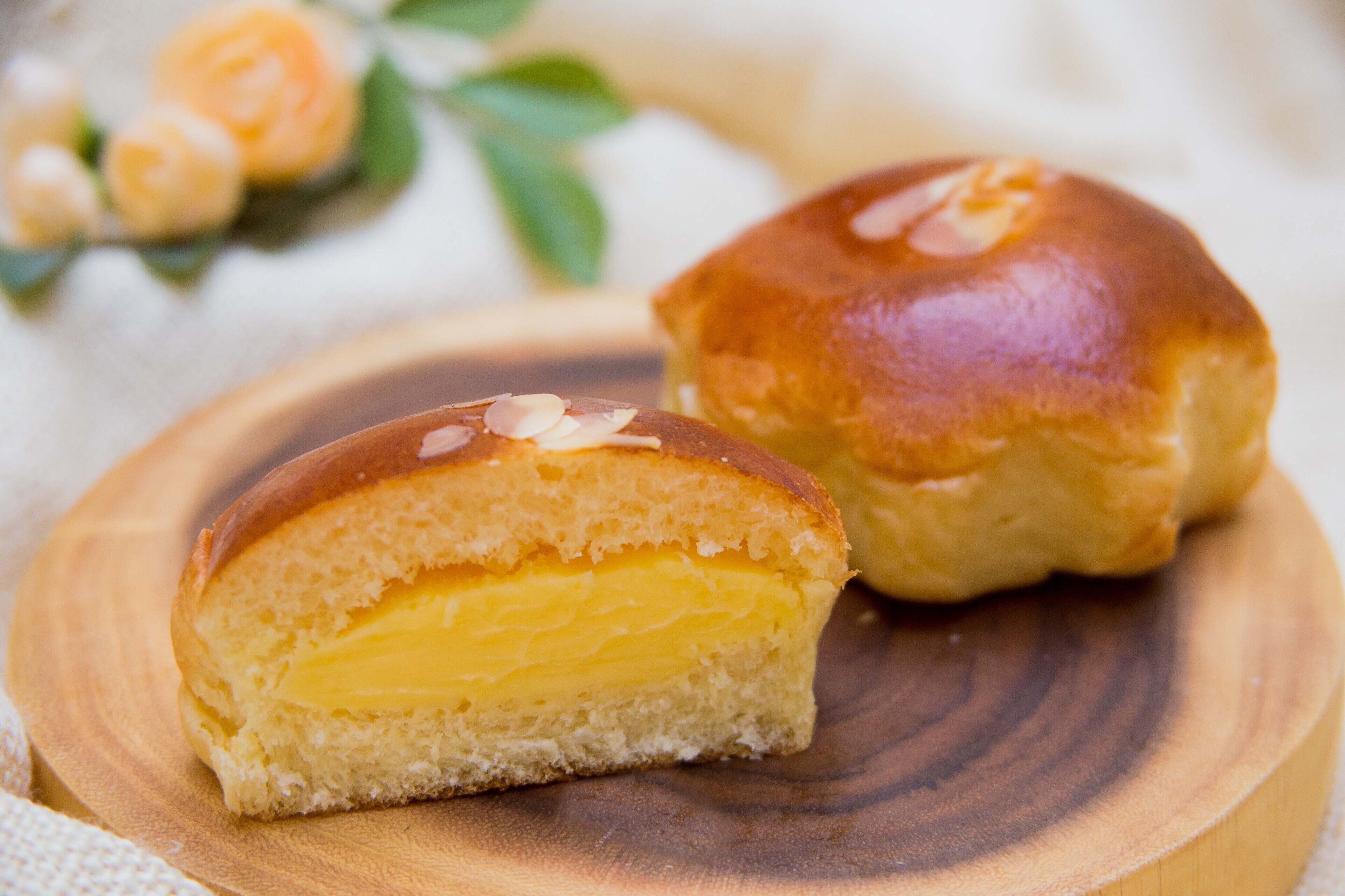 Un pastel con corteza dorada y relleno cremoso, sobre un plato de madera.