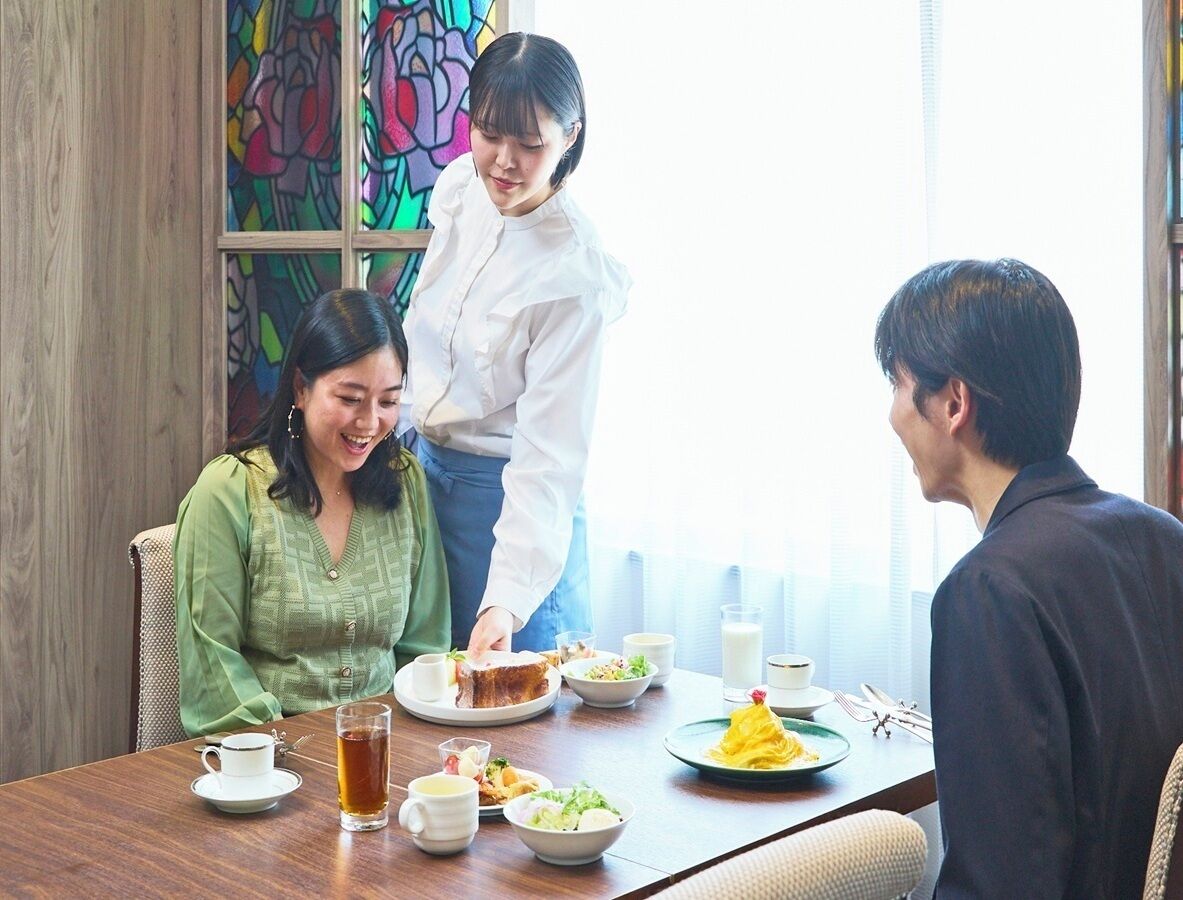 A dining table with plates of food, a cup, and a glass of tea.