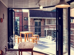 A modern room with a large window, a wooden table, and a chair. - Br. Guesthouse Hongdae (Seoul)