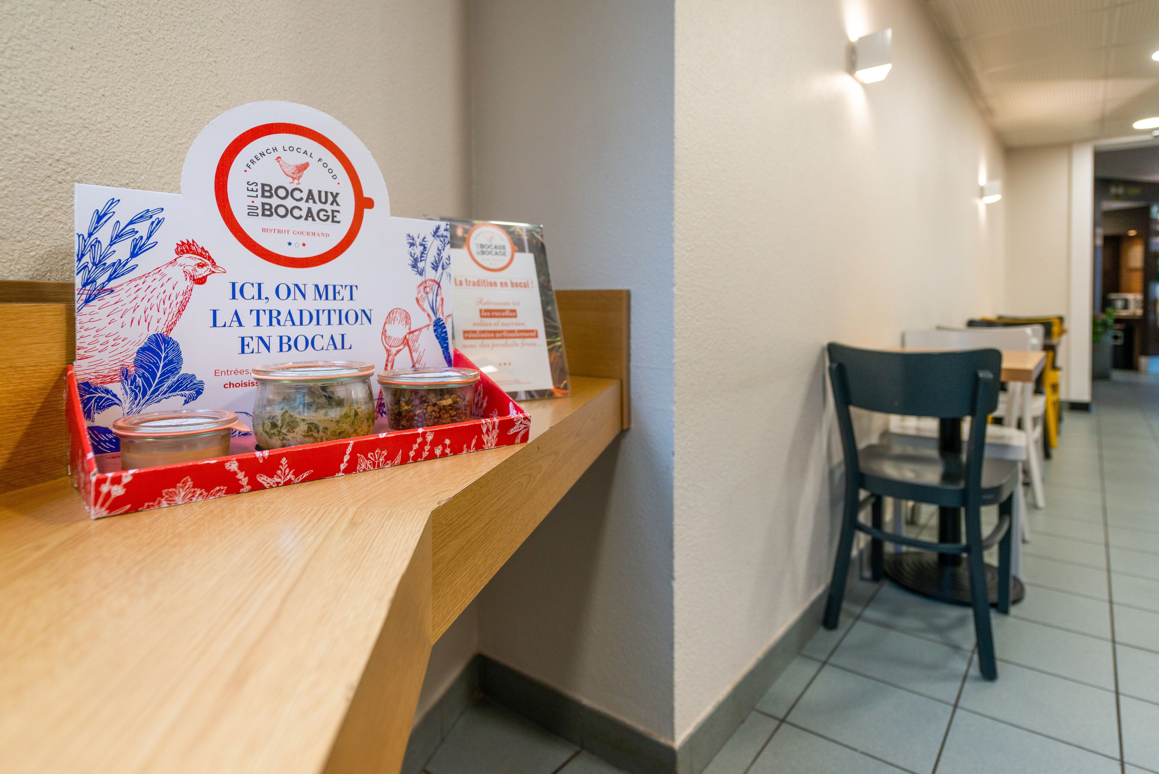 A reception area with a wooden counter displaying promotional materials and a sign for 'Les Bocas Bocasage'.