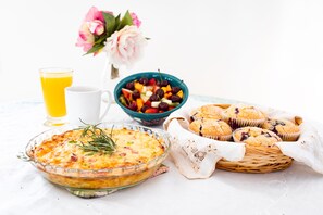 A breakfast setting with a glass pie, a bowl of mixed fruit, muffins, and a glass of orange juice. - The Inn at Tern Lake (Moose Pass)