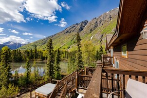 A wooden deck with a view of a lake and mountains.