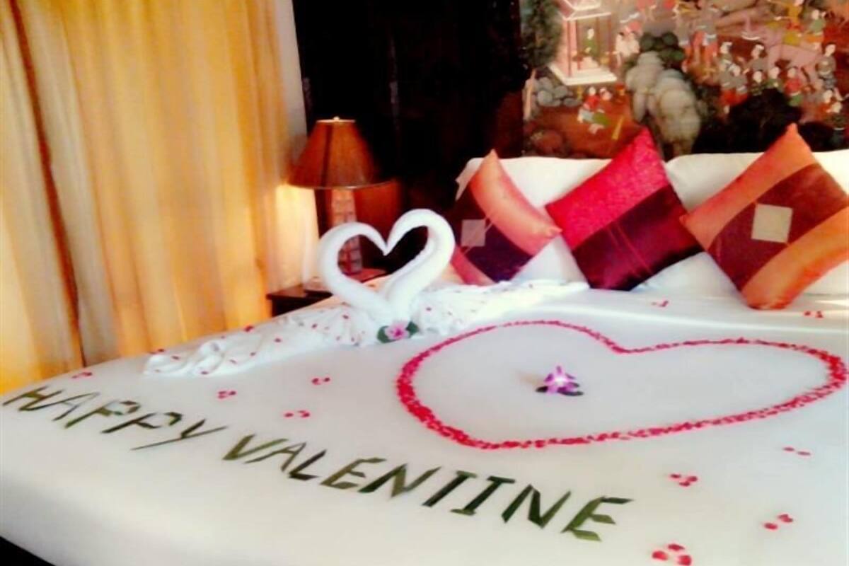 Une table décorée sur le thème de la Saint-Valentin, avec un motif en forme de cœur et l’inscription « Joyeuse Saint-Valentin ».