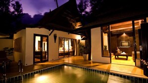A modern house with a swimming pool, large windows, and a well-lit interior. - Takolaburi Cultural Resort (Takua Pa)
