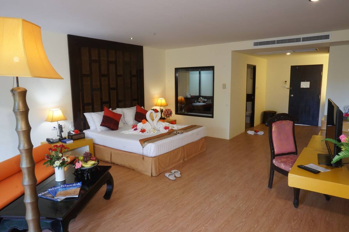Une chambre d’hôtel comprenant un lit, un bureau, une chaise, un canapé et une table basse.