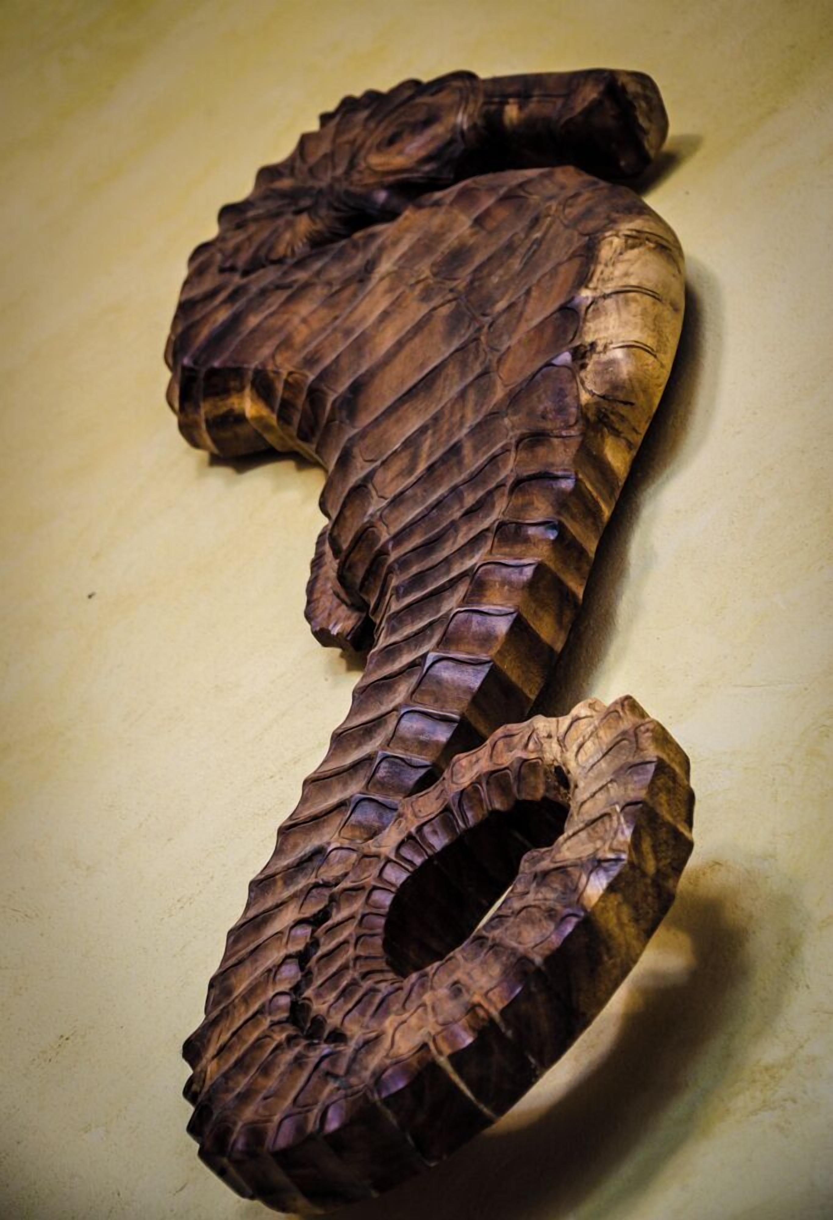 A wooden sculpture with a textured surface and a circular cutout.