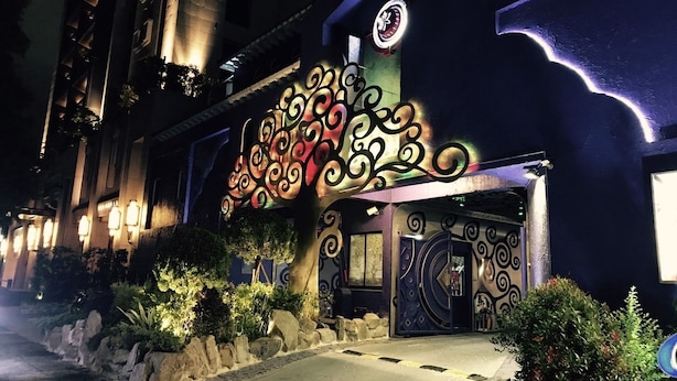 Una entrada de hotel con intrincados detalles metálicos y un reloj grande.