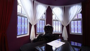 Una habitación con un ventanal amplio, una cama y una mesa con un menú.