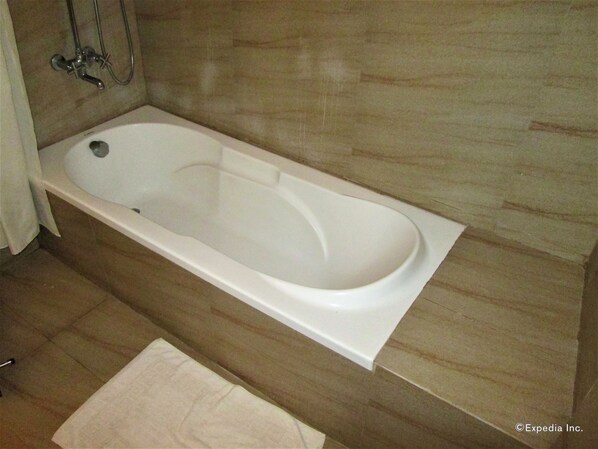 A modern bathroom with a freestanding bathtub, a showerhead, and a towel on the floor. - Chali Beach Resort and Conference Center (Cagayan de Oro)
