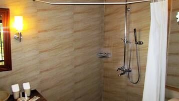 Un baño con ducha, toallero, lavabo e iluminación en la pared.