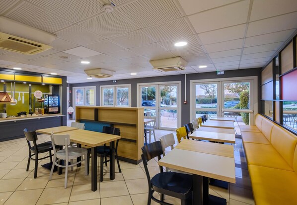 Un restaurant avec une salle à manger intérieure, un comptoir et de grandes fenêtres.