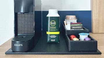 Een zwarte Krups haardroger, een waterfles van B&B Hotel en toiletartikelen in een zwarte tas.