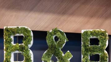 The letters 'B&B' covered in green moss.