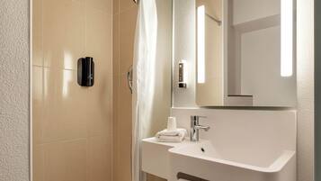 A modern bathroom with a shower, a sink, and a mirror.
