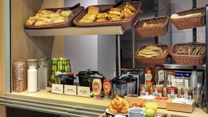 A breakfast buffet with various breads, pastries, condiments, and beverages. - B&B HOTEL LILLE Tourcoing Centre (Tourcoing)
