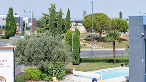 Un hôtel doté d’une piscine, entouré de verdure et offrant une vue sur le paysage urbain.