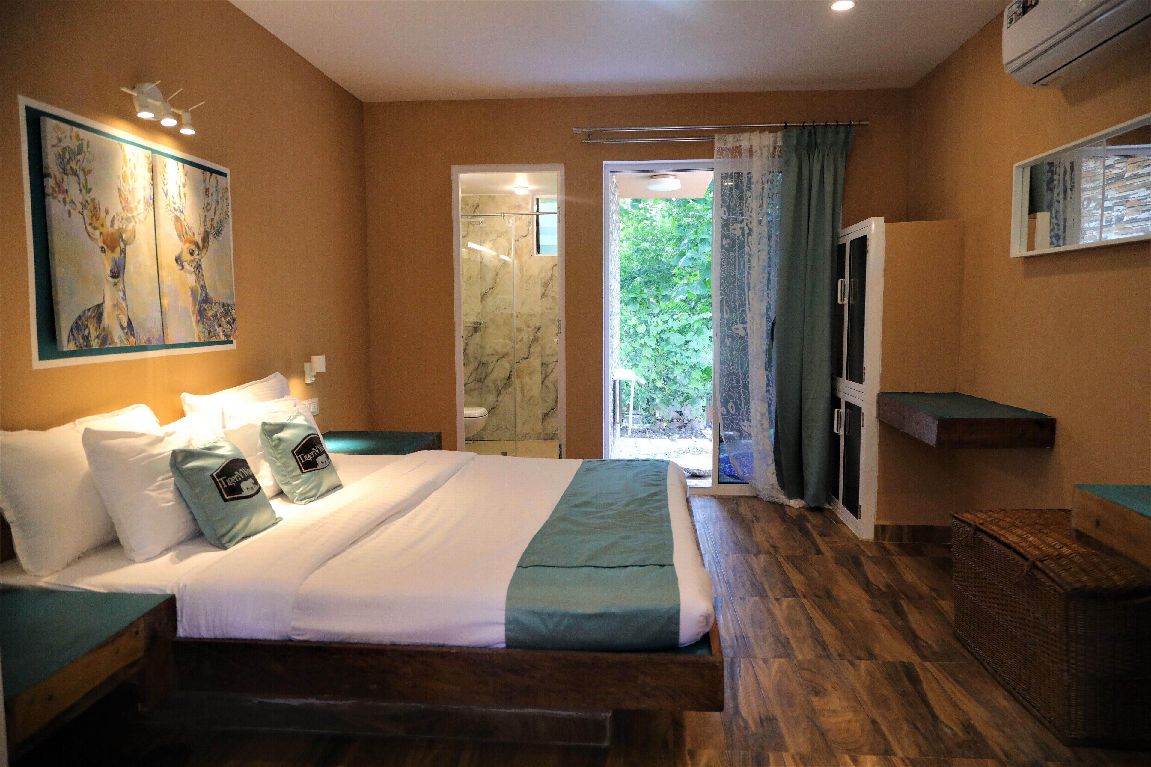 Camera da letto con un letto, un comodino, un quadro, una doccia e vista sul verde.