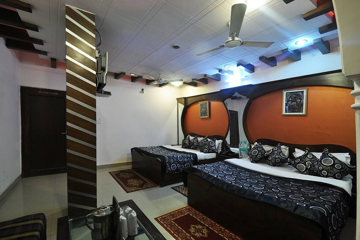 A hotel room with two beds, a ceiling fan, and a large mirror.