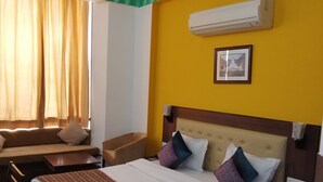 Une chambre d’hôtel avec un lit, un canapé, une petite table et une chaise.