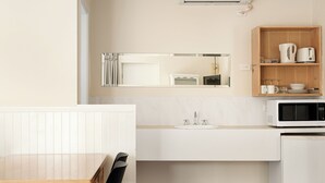 A modern kitchen with a microwave, sink, and cabinet. - Catalina Motel Lake Macquarie (Toronto)