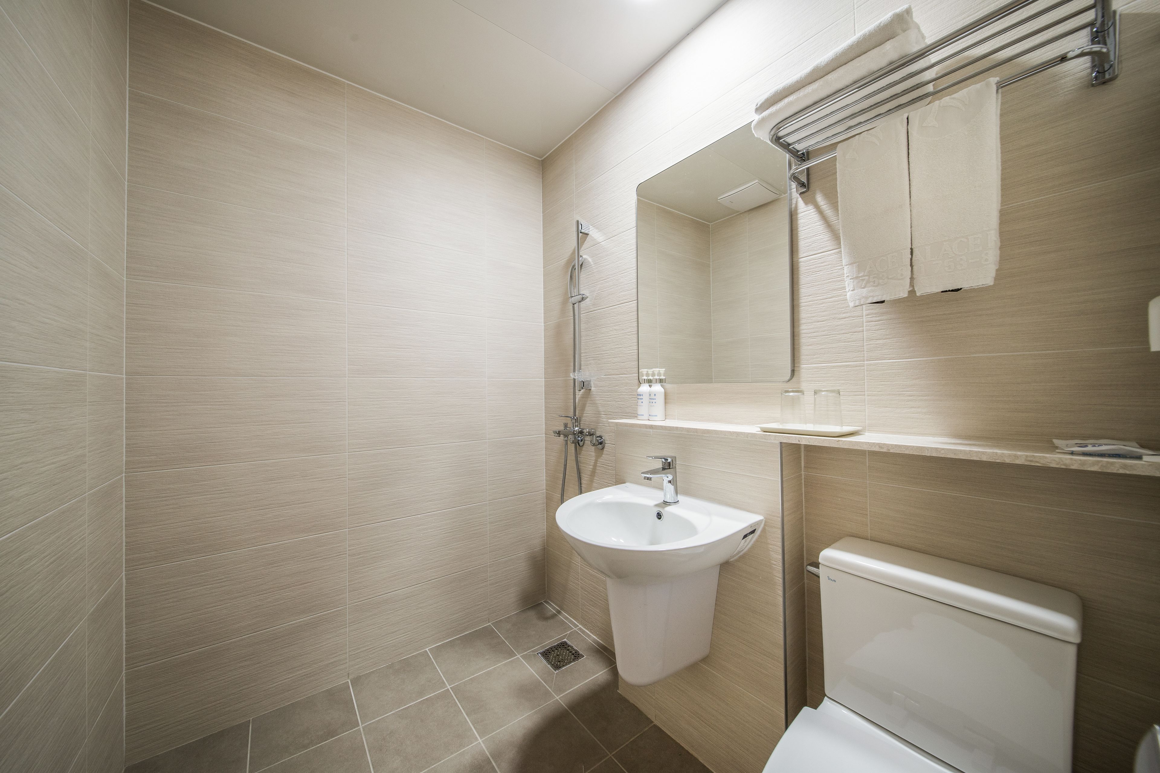 A modern bathroom with a shower, sink, and toilet.
