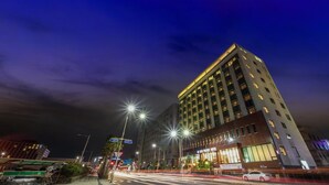 Een modern hotel met een opvallende entree en meerdere verdiepingen.