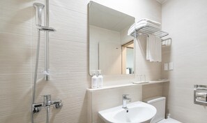 Un baño moderno con ducha, lavamanos y perchero para toallas.