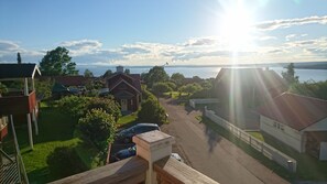 Ein Wohngebiet mit Häusern, einer Straße und einem Gewässer im Hintergrund.