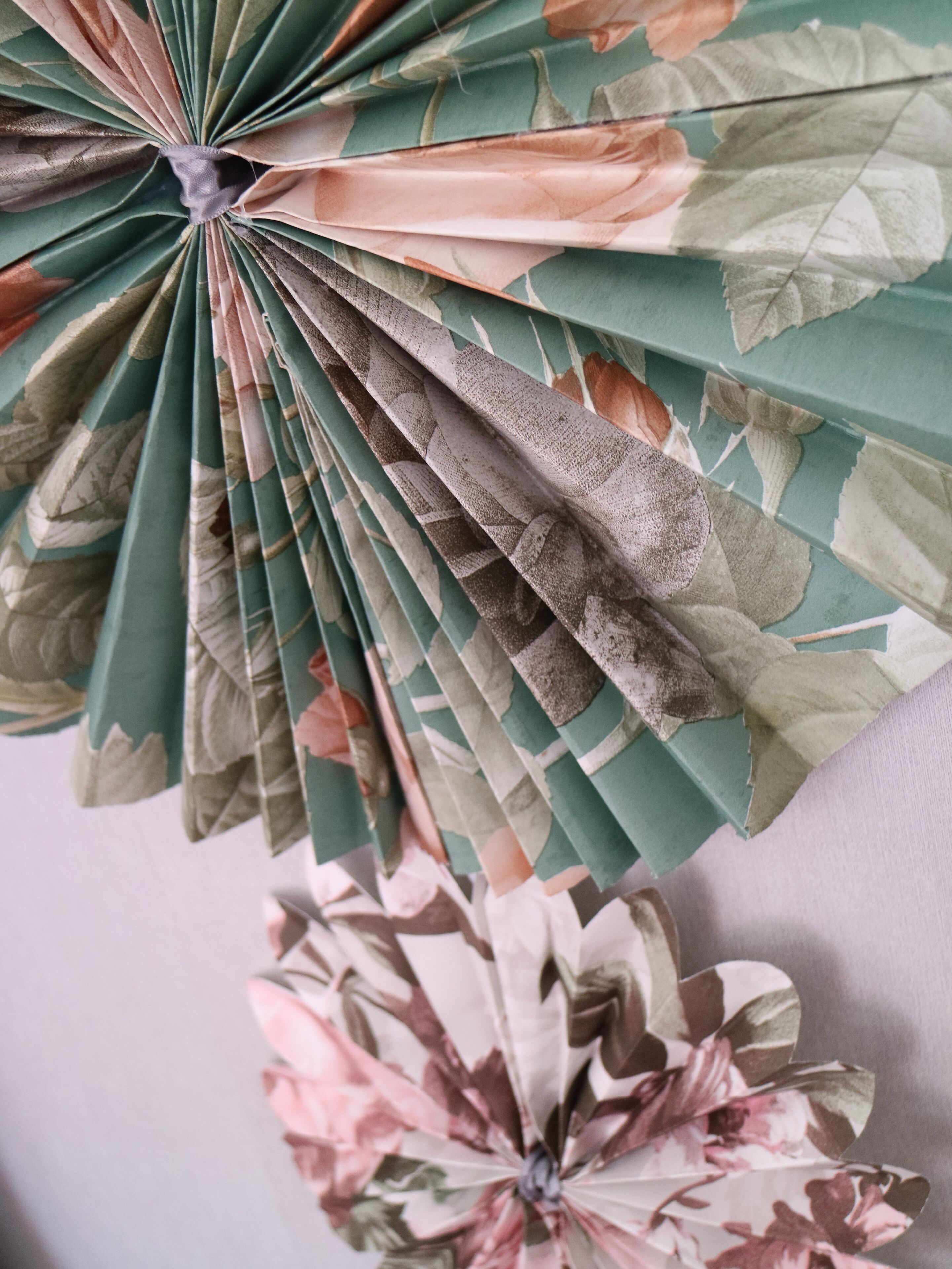A folded fan with a floral pattern.
