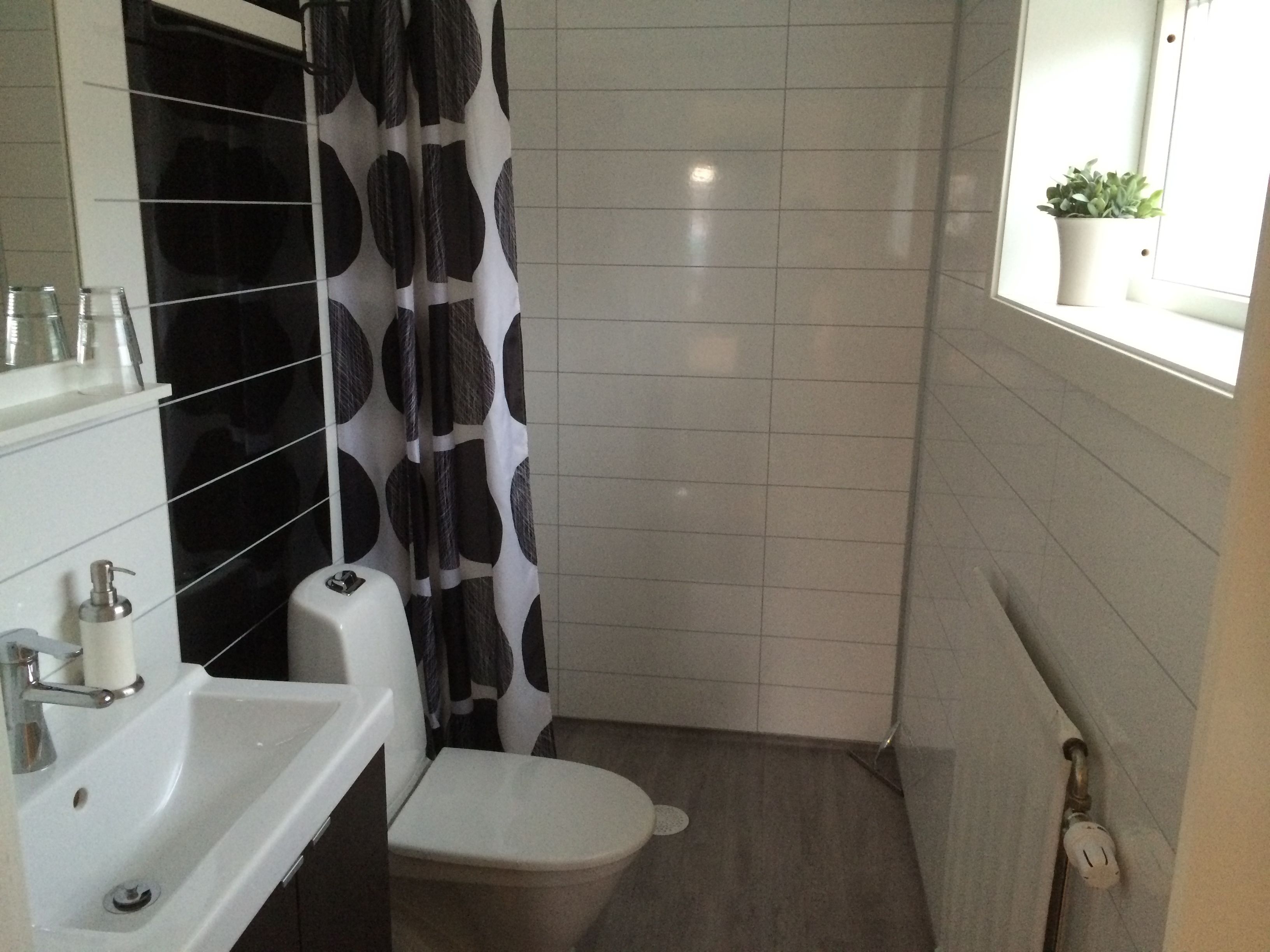 A bathroom with a white sink, toilet, and shower curtain.