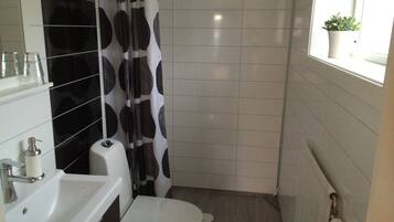 A bathroom with a white sink, toilet, and shower curtain.