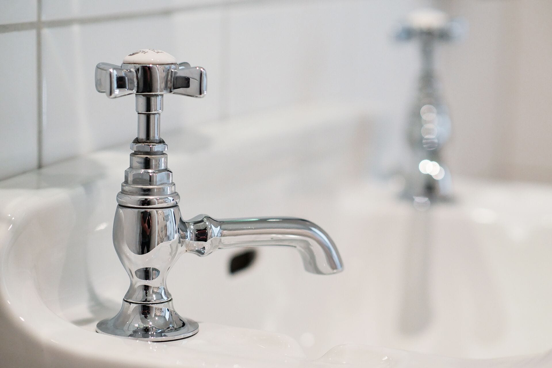 A bathroom sink with a chrome faucet and a mirror.