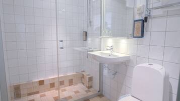 Une salle de bain avec une douche, un lavabo et des toilettes.