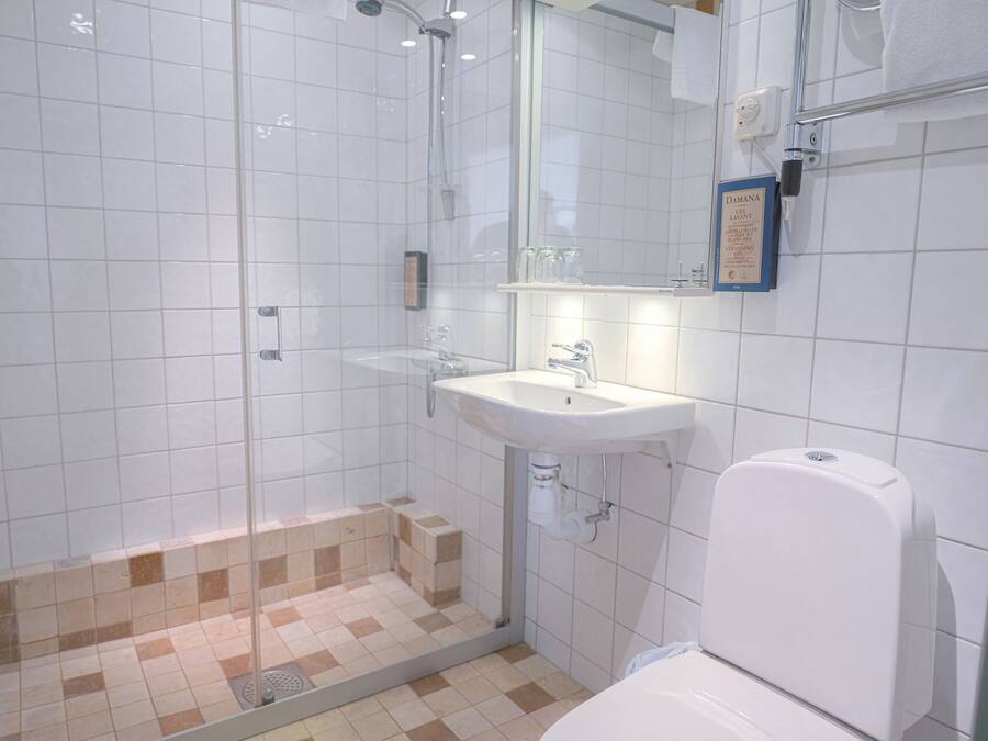 Une salle de bain avec une douche, un lavabo et des toilettes.